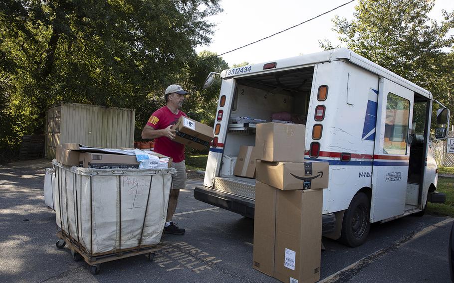 Postal carrier Robert Nagel loads packages onto a mail truck in Winterville, Ga. 