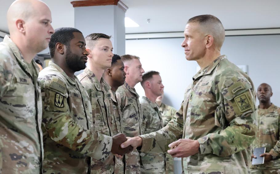 Sgt. Maj. of the Army Michael Grinston awards coins to select exemplary enlisted and noncommissioned soldiers on Dec. 14, 2022, at Camp Arifjan, Kuwait.