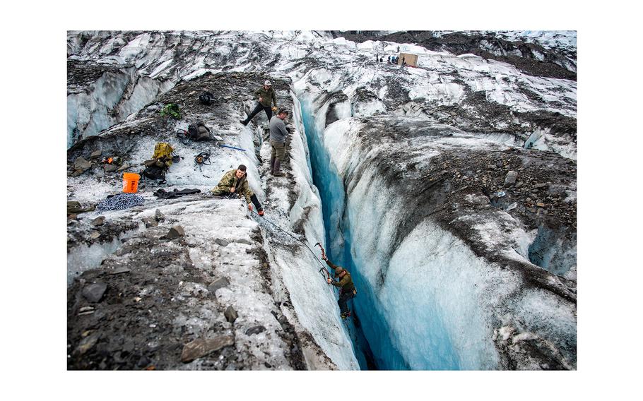 An Operation Colony Glacier recovery team member climbs out of a crevasse after searching the bottom for possible human remains, personal effects and equipment at Colony Glacier, Alaska, June 16, 2023.