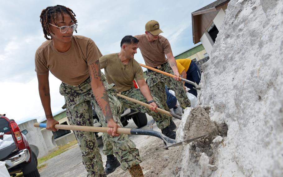 Machinist’s Mate 2nd Class Dasia Washington shovels sand into a bag aboard Naval Air Station Jacksonville in preparation for Hurricane Idalia, Aug. 28, 2023.