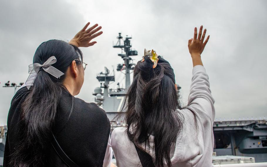 Sailors' family members wave farewell as the aircraft carrier USS Ronald Reagan departs Yokosuka Naval Base, Japan, May 16, 2024.