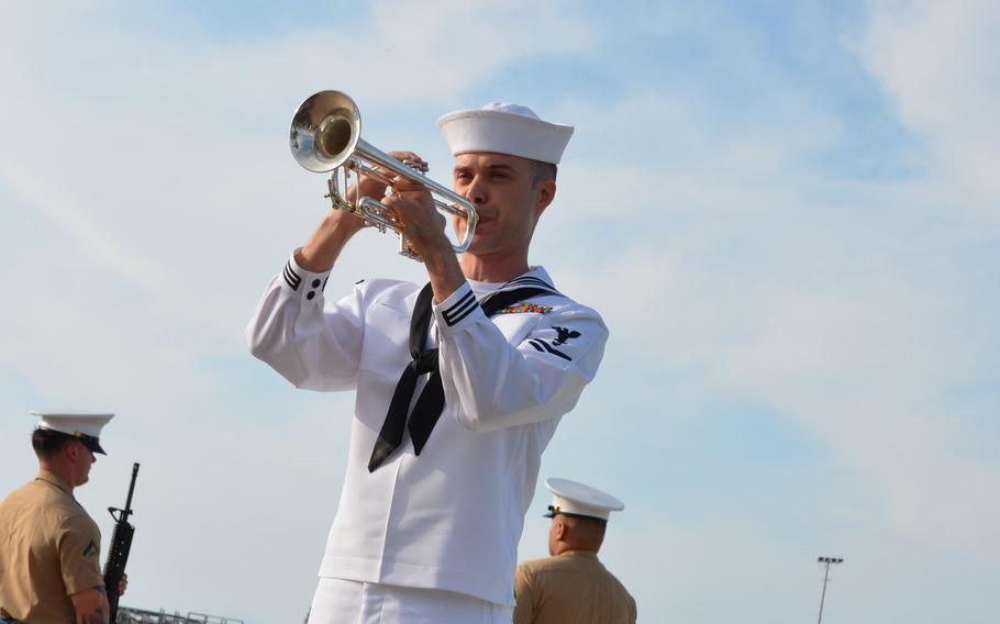 A sailor plays taps during a ceremony at the Pearl Harbor National Memorial, Dec. 7, 2022, marking the 81st anniversary of the surprise attack. 