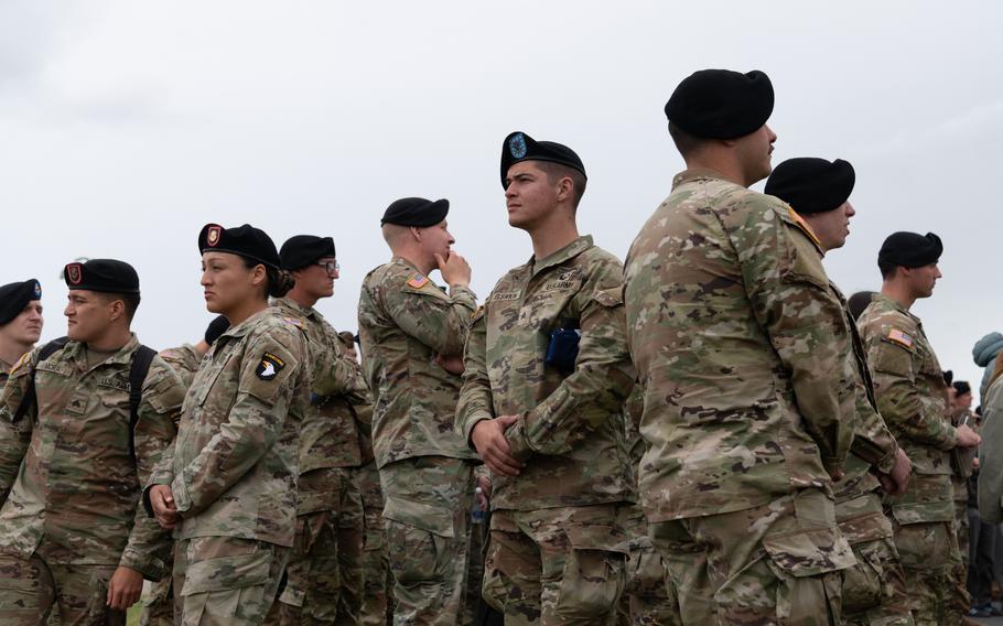 Uniformed soldiers stand in a group.
