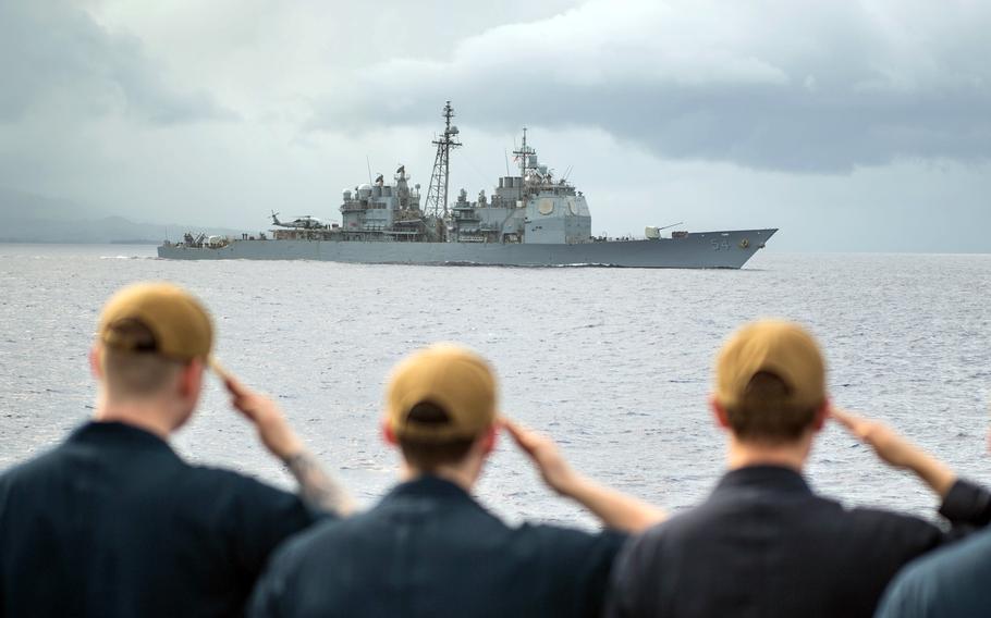 The USS Antietam steams past the USS Shiloh as the Shiloh's sailors salute the guided-missile cruiser in the Philippine Sea, March 9, 2020.