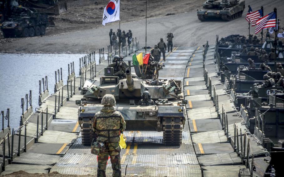 South Korean K1 88 tanks cross a ribbon bridge during training at the Imjin River, South Korea, March 20, 2024.