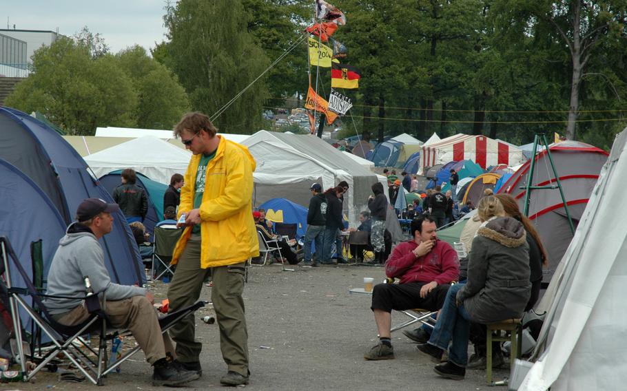 People sit and chat by tents.