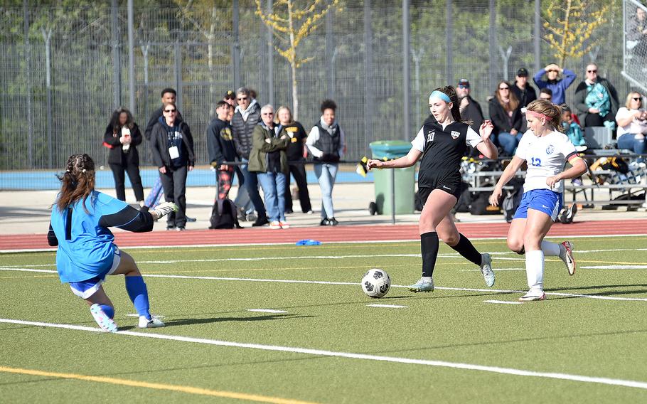 Stuttgart winger Madeleine Fleming goes in on goal as Ramstein goalkeeper Liberty Snyder, left, charges off her line and center back Abby Belote chases during a match April 27, 2024, at Stuttgart High School in Böblingen, Gemany.