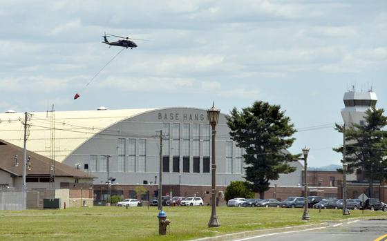 A Blackhawk helicopter from the Conn. National Guard’s 169th Aviation Regiment at Bradley Airport flies over the Base Hangar at Westover Air Reserve Base in Chicopee, Mass., during a training mission. The base will evaluate operations if there is a government shutdown.