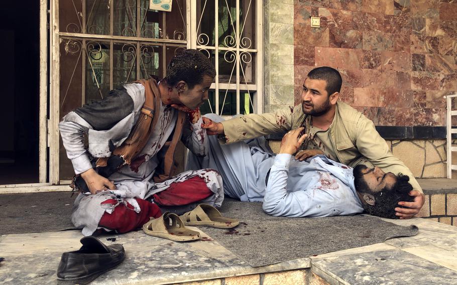 An injured man lies down after a bomb blast in Mazar-e-Sharif, the capital city of Balkh province, in northern Afghanistan, Saturday, March 11, 2023. A bomb exploded on Saturday during an award ceremony for journalists in the city. 