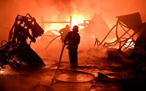 Ukrainian firefighters work to extinguish a fire at the site of a drone attack on industrial facilities in Kharkiv on May 4, 2024, amid the Russian invasion of Ukraine. (Sergey Bobok/AFP/Getty Images/TNS)