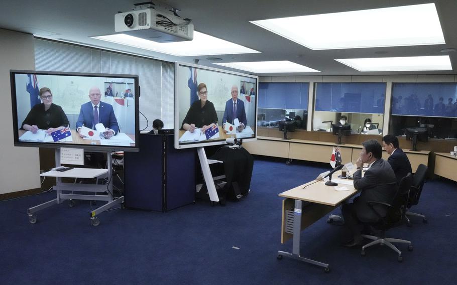 Japanese Foreign Minister Toshimitsu Motegi, second right, and Defense Minister Nobuo Kishi, right, attend a video conference with Australian Foreign Minister Marise Payne, left on screen, and Australian Defense Minister Peter Dutton, right on screen, at Foreign Ministry in Tokyo during their two-plus-two ministerial meeting Wednesday, June 9, 2021, in Tokyo.