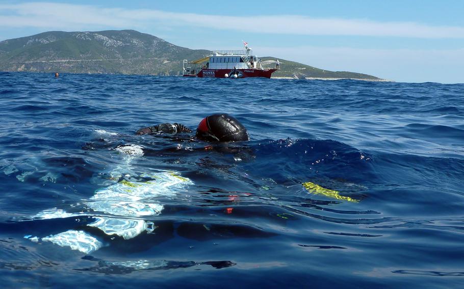A diver prepares to descend into waters off Croatia Aug. 14, 2022, to film and document World War II aircraft wreckage on the seafloor.
