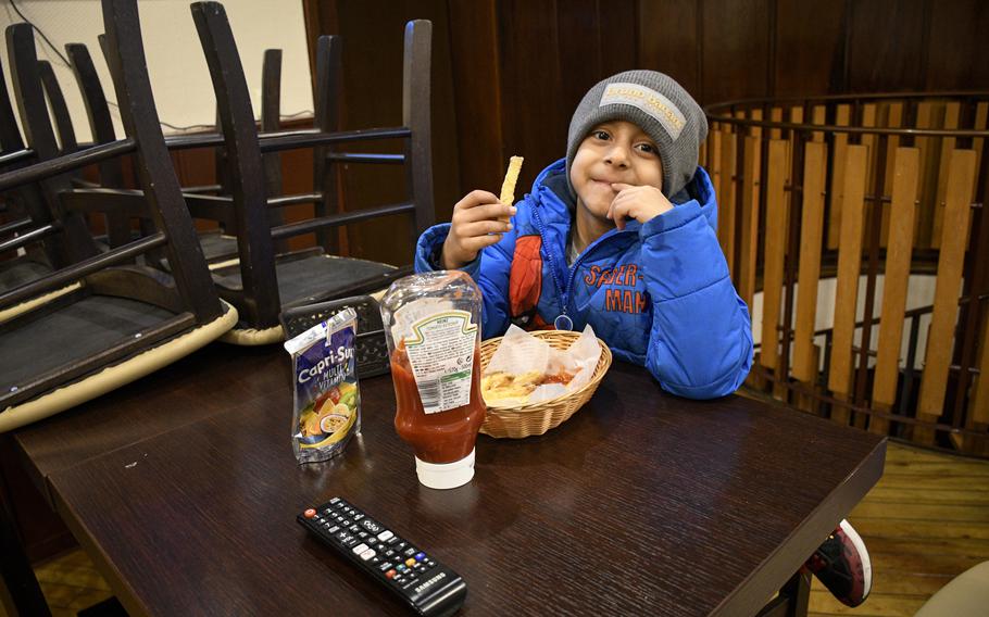 A child munches on a basket of battered fries from Ishan's Gourmet Hot Wings in Kaiserslautern. 