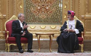 Two men seated in ornate chairs in a decorated room.