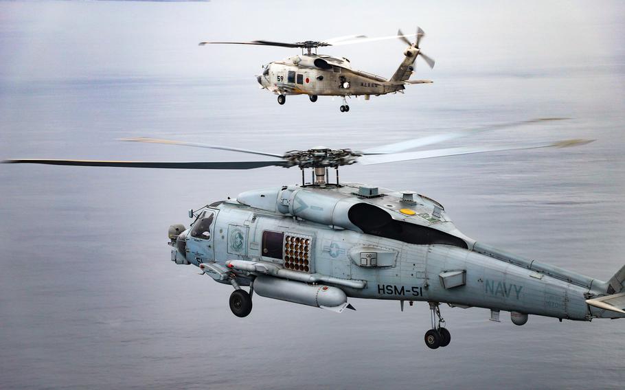 A U.S. Navy MH-60R Seahawk flies off Japan's southern coast with a Japanese Maritime Self-Defense Force SH-60K on Sept. 14, 2021.