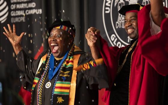 Jacklyn Wilson, left, throws confetti to celebrate receiving her Master of Business Administration degree from Gregory Fowler, president of University of Maryland Global Campus, during the commencement ceremony at Ramstein Air Base, Germany, May 3, 2025. Wilson traveled from Saudi Arabia to attend in person.