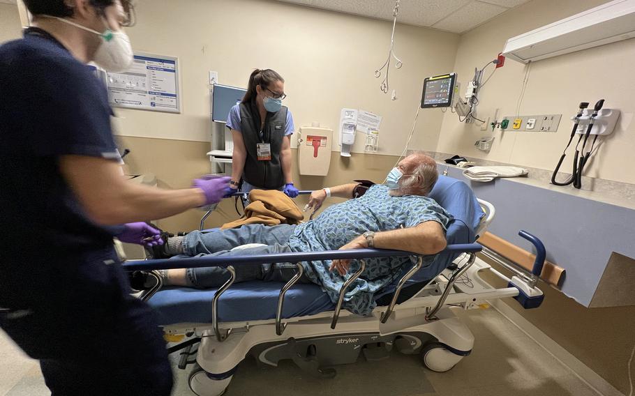 Emergency medicine physician Anne Dulski, center, speaks with Stanley Lomas, who arrived at Kent Hospital by ambulance with chest pains. Nurse Alex Boie, left, assists Dulski. 