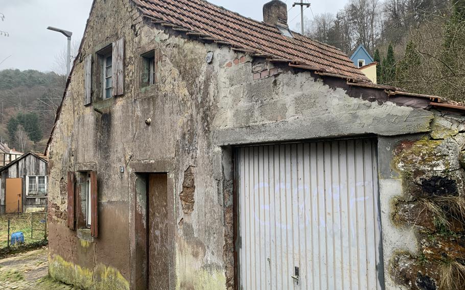 A path that leads to the ruins of the 11th century Frankenstein Castle passes this decrepit building at the foot of the hill before going between the town's Protestant church and a graveyard, Sunday, Jan. 23, 2022. 