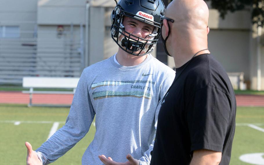Zama senior quarterback Dominic Peruccio chats it up with coach Scott Bolin. Bolin is in his sixth season at the Trojans' helm and Peruccio returns after two years of playing football in Texas.