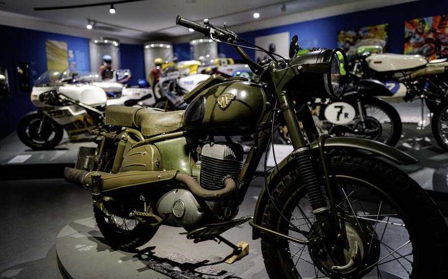 A mass-produced 1959 Maico two-stroke motorcycle of the West-German army stands in contrast to custom racing motorcycles at the German Motorcycle Museum in Neckarsulm, Jan. 21, 2024. The small German manufacturer Maico sent a motorcross champion to demonstrate the bike to military officials, earning the company the lucrative contract over other bidding companies.