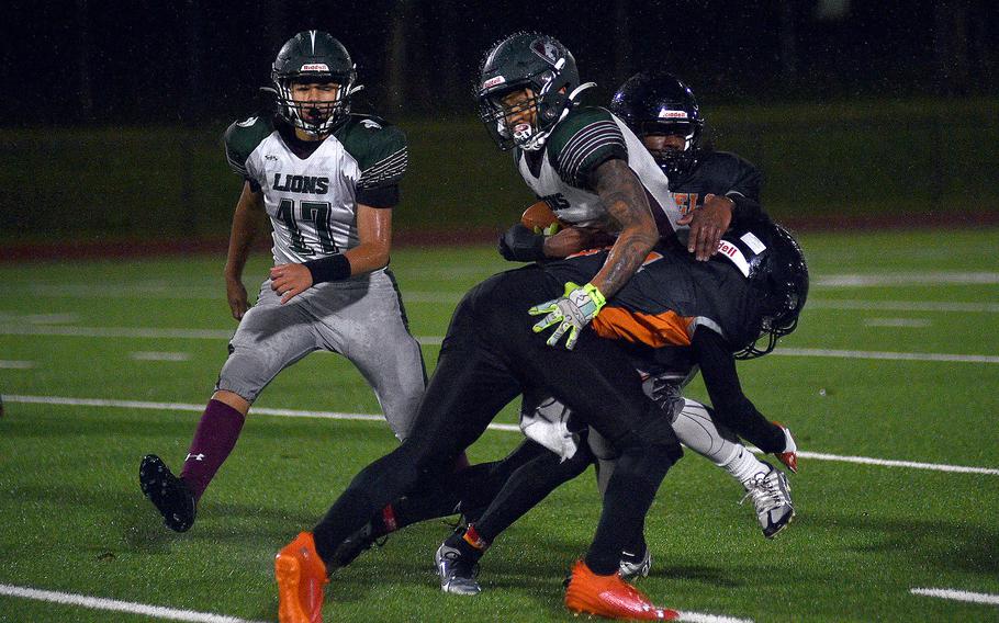 Spangdahlem defenders Robert Leggett, front, and Messiah Smith tackle AFNORTH running back Connor Luminarias during the DODEA-Europe Division III championship game on Oct. 29, 2023, at Spangdahlem High School in Spangdahlem, Germany.