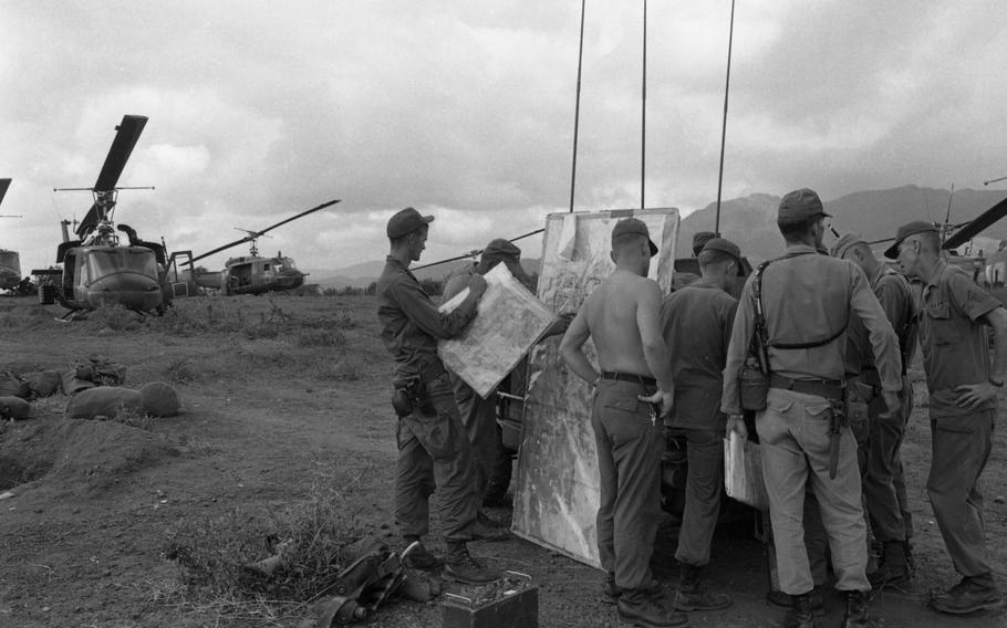 A number of helicopter pilots look over a situation map at Operation White Wing. The map is broken down into code name, section and pilots come here for info on where to fly and where the action is, and to report anything they have seen.