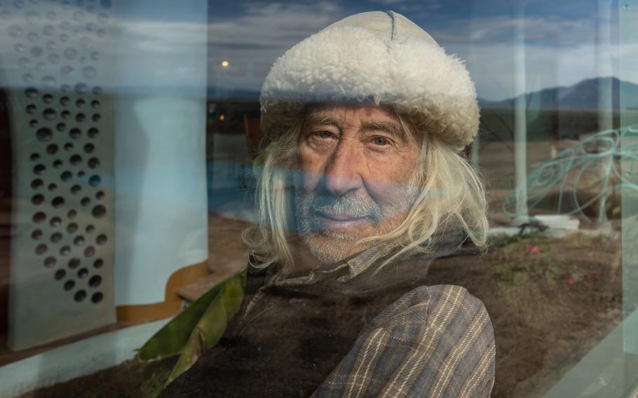 Mike Reynolds poses in one of his Earthships, which he calls “vessels,” in Taos, N.M, on December 8, 2021. 