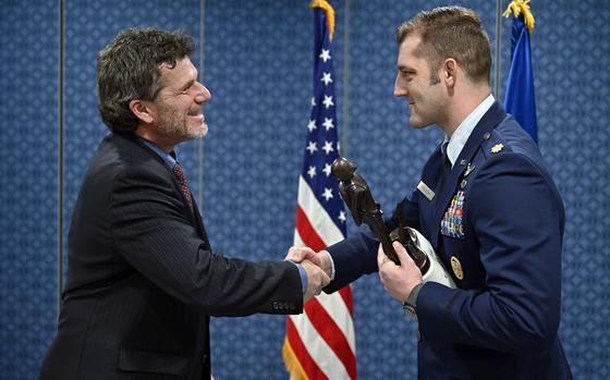 Kyle Anderson, a member of the Kolligian family, congratulates Maj. Brady Augustin after presenting him the 2022 Koren Kolligian Jr. Trophy at the Pentagon in Arlington, Va., Feb. 7, 2024. 