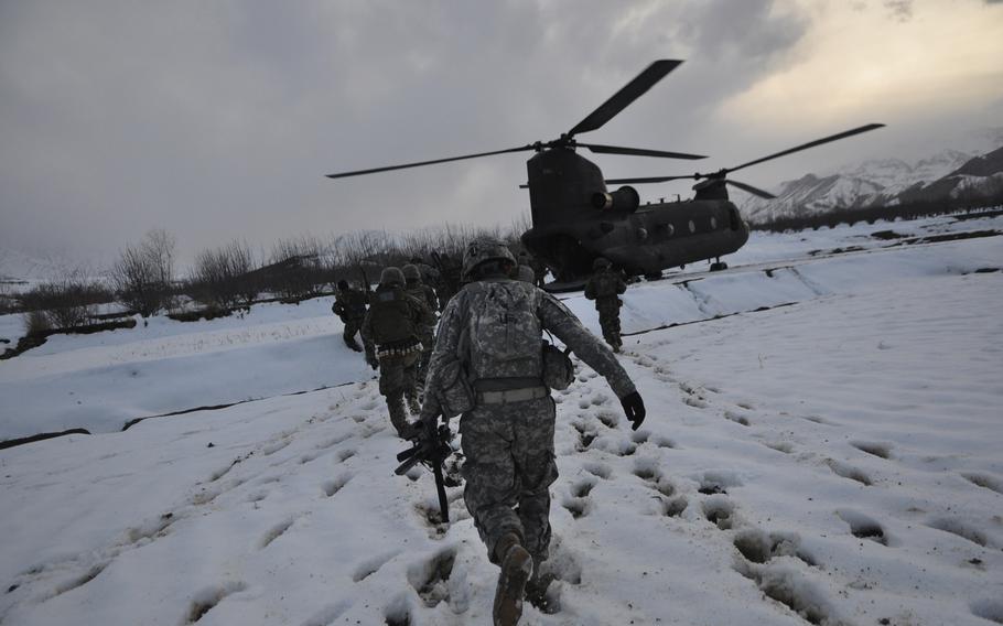 U.S. and Afghan troops walk to a waiting helicopter after a mission in Wardak province.