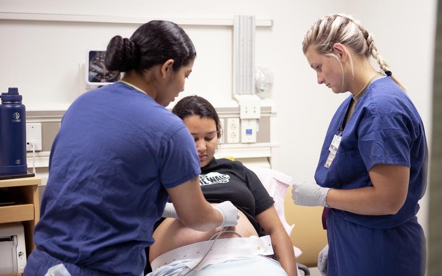 Air Force Staff Sgt. Sabra Szavuly, a medical technician, trains alongside Petty Officer 3rd Class Diamond Goldberg to monitor an expectant mother July 18, 2023, at U.S Naval Hospital Okinawa in Japan. A group of medical professionals is seeking to jumpstart hiring of qualified military spouses on Okinawa, a move they say will pay dividends for the chronically understaffed hospital.