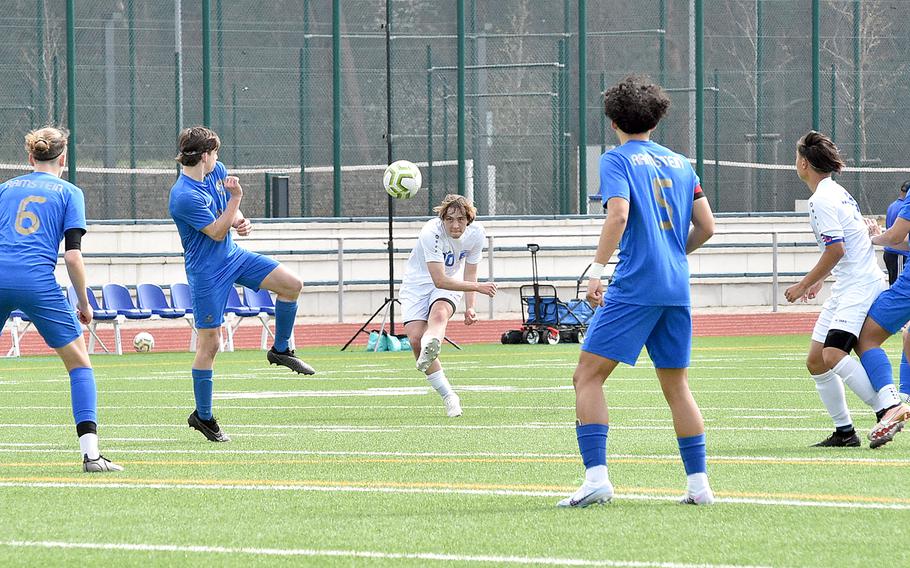 Wiesbaden forward Asher Anderson shoots from distance during Saturday's match at Ramstein High School on Ramstein Air Base, Germany. Defending, from left, are the Royals' Kelan Vaughn, Jayden Andrews and River Rocha.