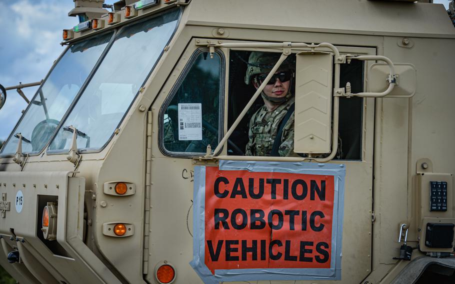 A soldier looks from driver's seat of an autonomous transport vehicle during a demonstration at the Joint Multinational Readiness Center in Hohenfels, Germany, June 8, 2022. The vehicle can be programmed to drive all on its own - making the driver a safety precaution.