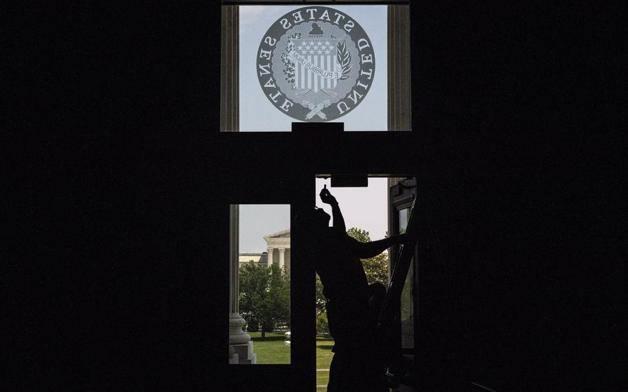 A worker fixes a door at the Capitol in May 2021. 