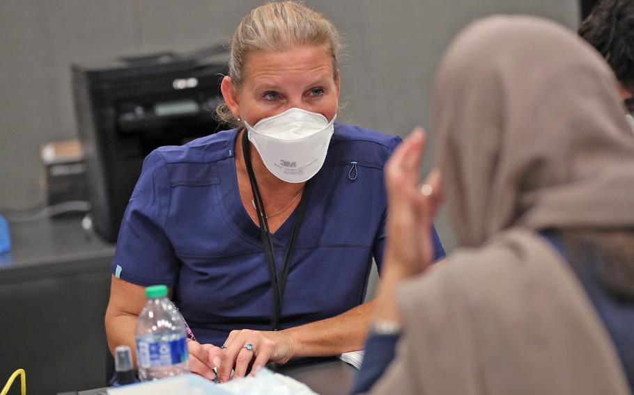 A medical professional speaks with an evacuee in the acute medical building as part of Operation Allies Welcome, Thursday, Oct. 14, 2021, at Camp Atterbury in Edinburgh, Ind.