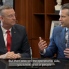 Doug Collins watching Pete Hegseth talk, with Hegseth gesturing.