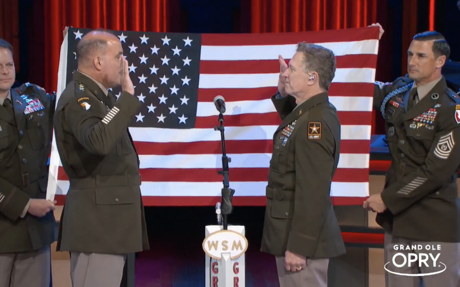 Gen. Andrew Poppas, commander of Army Forces Command, left, administers the oath of enlistment to country singer Craig Morgan during a concert at the Grand Ole Opry in Nashville, Tenn., Saturday, July 29, 2023.