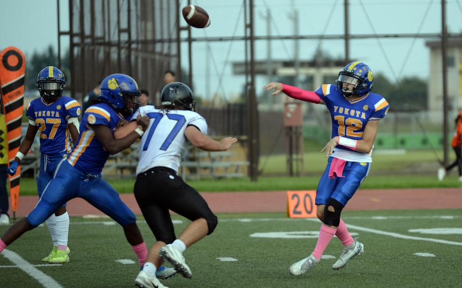 Yokota quarterback Ethan Bricker lets fly in front of Osan defender Samuel Myrup.