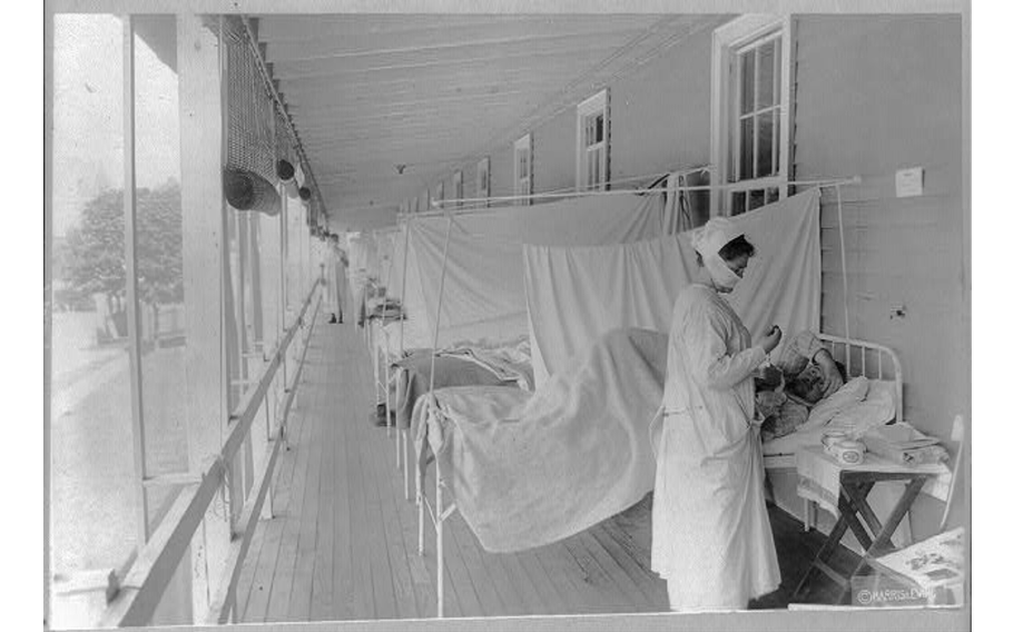 A nurse takes a patient’s pulse in the influenza ward at Walter Reed Hospital, Washington, D.C. , 1918 or 1919.