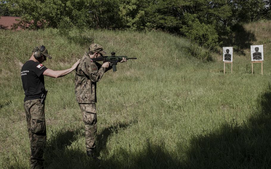 Maks Seroczynski, a recent high school graduate considering a military career because of the war in Ukraine, learns about weapon safety and trains in shooting during weekend workshops organized at an outdoor shooting range in Wloclawek, Poland, in late June. 