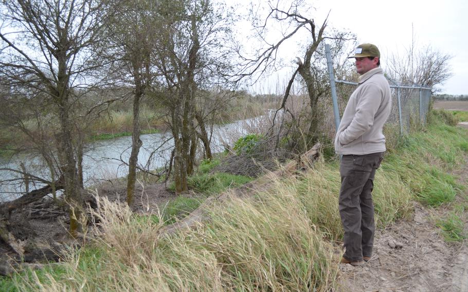 Sam Sparks, a third-generation farmer in Cameron County, Texas, looks at the Rio Grande from his land on Jan. 20, 2022. He built a small fence near the water to try and deter people from crossing the river because he has dealt with ongoing theft and damage. 