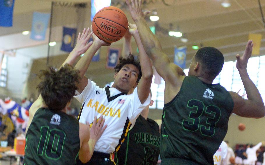 Kadena's Cory Tripp finds himself bottled up by Kubasaki defenders Troy Harris, T.J. Reese and Brayden Milam.