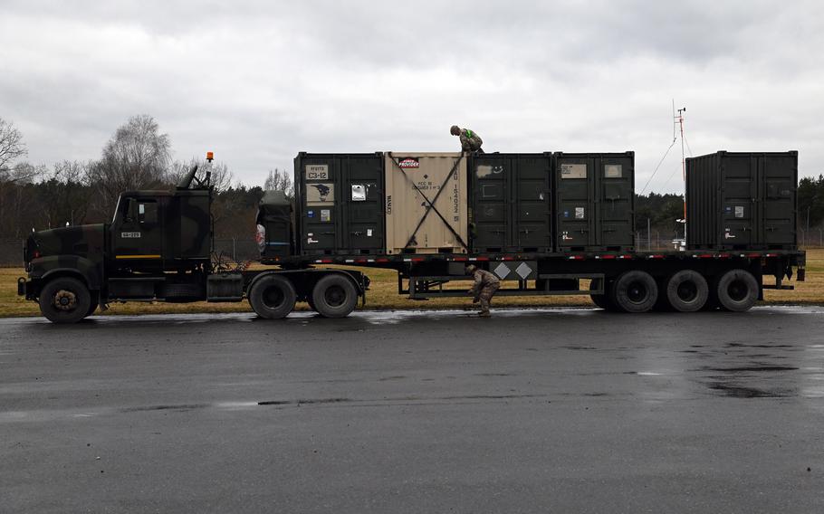 Soldiers secure cargo to a truck at Vilseck Army Airfield, Germany, Feb. 9, 2022, as the 2nd Calvary Regiment prepares to deploy to Romania.