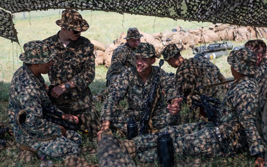 Marines with 1st Battalion, 24th Marine Regiment, rest in the shade after establishing a base camp at Camp Grayling, Mich., during the Northern Strike military exercise, Aug. 7, 2025.