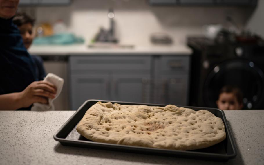 An Afghan family makes a traditional flatbread after people donated flour for them in Falls Church, Va., on Dec. 6. 