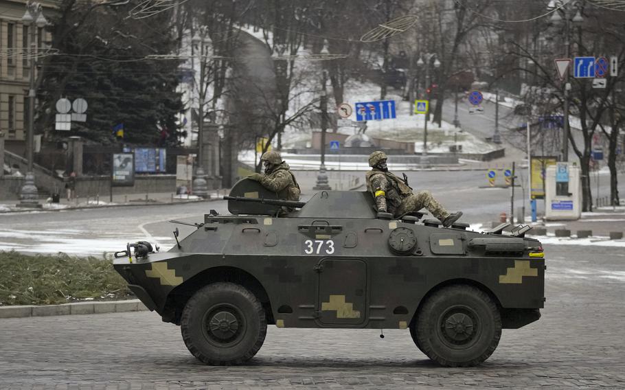 Ukrainian servicemen ride on top of an armored personnel carrier speeding down a deserted boulevard during an air raid alarm, in Kyiv, Ukraine, Tuesday, March 1, 2022. The U.N.’s refugees chief is warning that many more vulnerable people will begin fleeing their homes in Ukraine if Russia’s military offensive continues and further urban areas are hit.