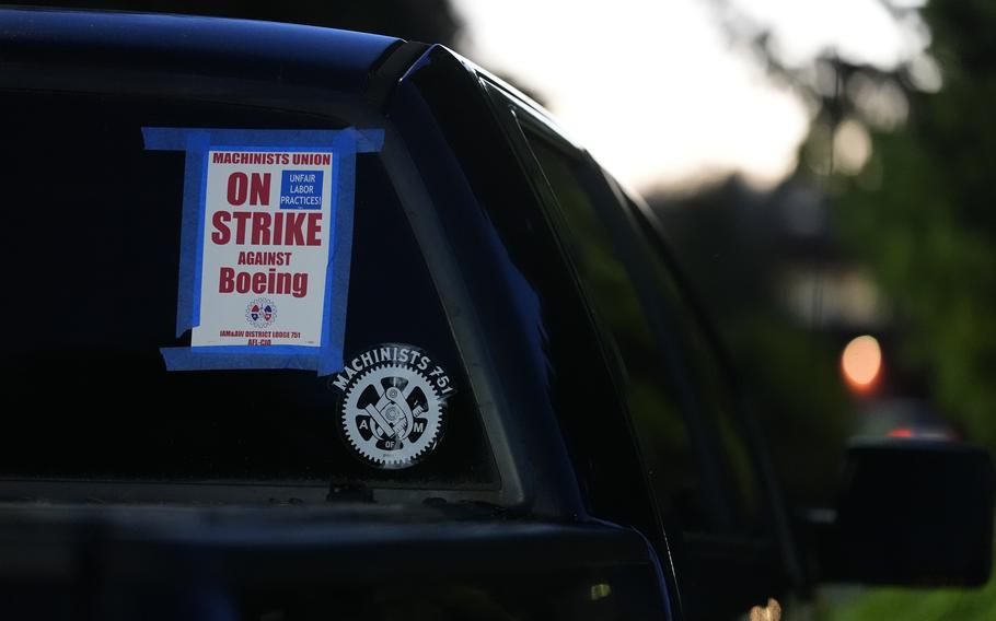 A truck displays a sign that says “On strike against Boeing.”