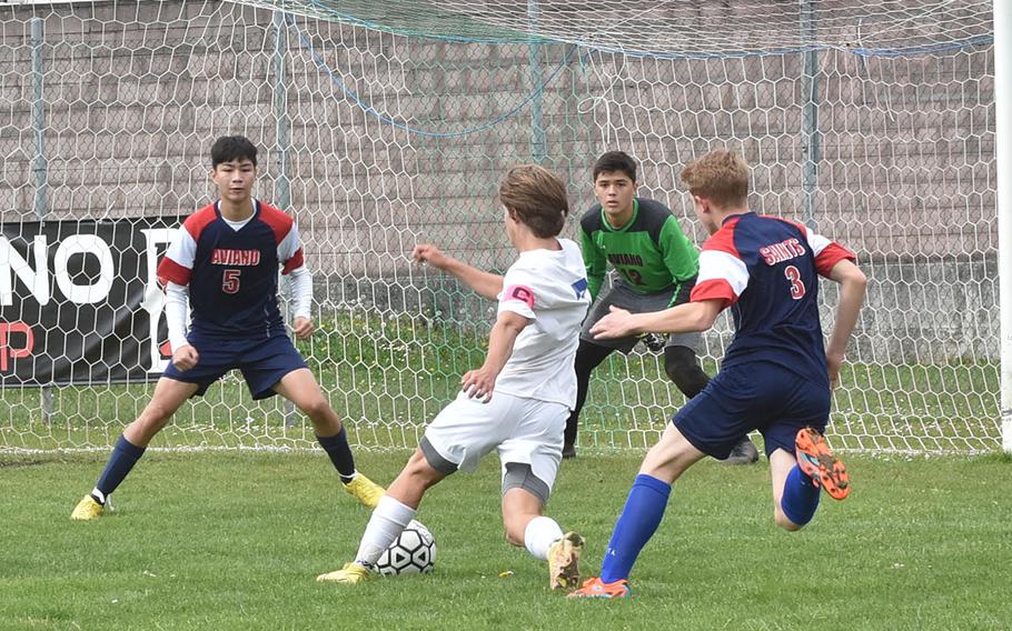 Sigonella's Tim Garcia tries to score against Aviano's Joseph Guerrero, from left, Santiago Wright and Wyatt McGowen, on Saturday, April 15, 2023.