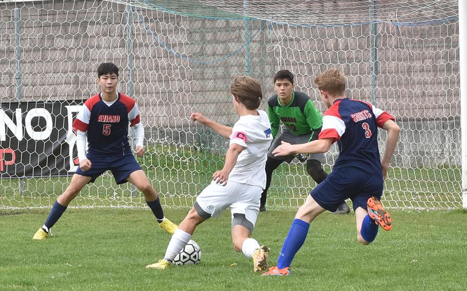 Sigonella's Tim Garcia tries to score against Aviano's Joseph Guerrero, from left, Santiago Wright and Wyatt McGowen, on Saturday, April 15, 2023.