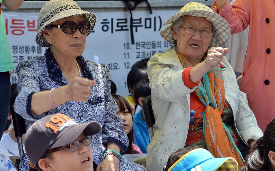 Bok-dong Kim, left, and Won-ok Gil chant during a protest near the Japanese Embassy in Seoul, South Korea, May 21, 2014. Both women were forced into prostitution by Japan during World War II. 