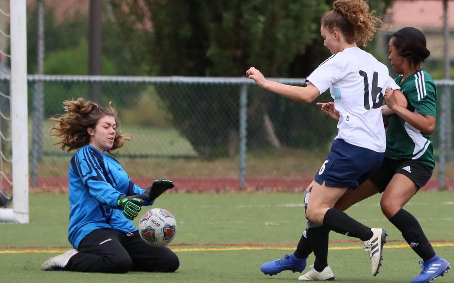 Daegu goalkeeper Margaret Hager stuffs a shot by Osan American’s Corbyn Kubalek.